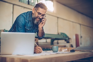 business owner on the phone writing something down