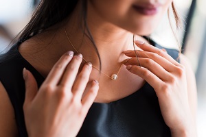 woman touching necklace around her neck